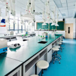 Empty school lab with modern lab equipments , sitting stools , gereen board, windows and doors.