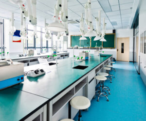 Empty school lab with modern lab equipments , sitting stools , gereen board, windows and doors.