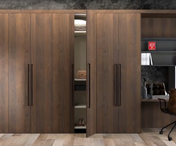 Modern wooden wardrobe with a built-in study desk, open shelves, and a stylish office chair in a well-designed room.